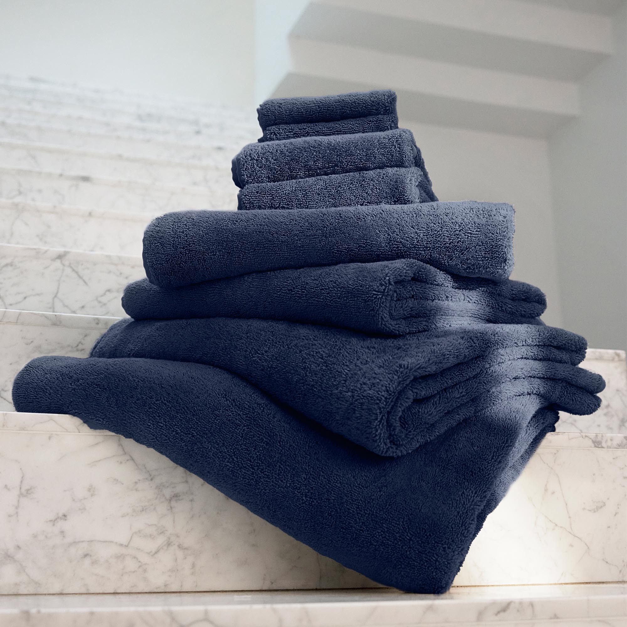 a stack of blue towels on a set of stairs