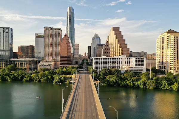 an aerial view of a bridge over a body of water with a city skyline in the background