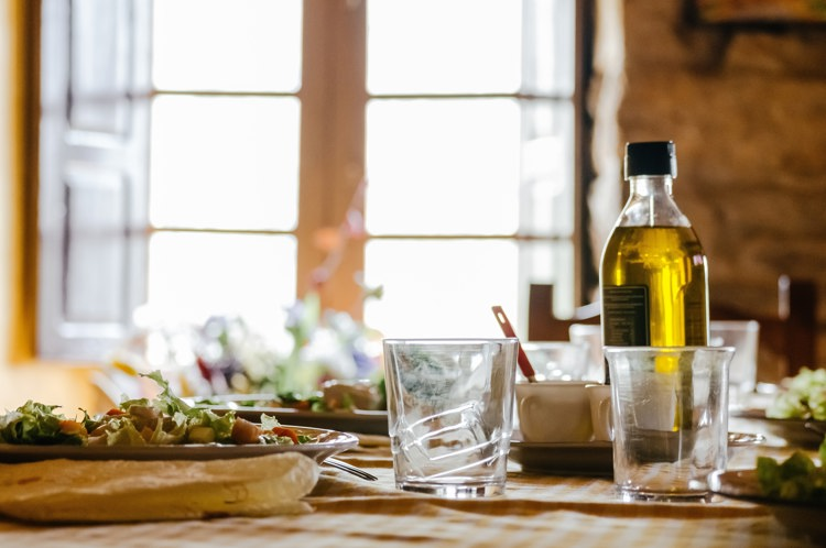 a bottle of olive oil sits on a table