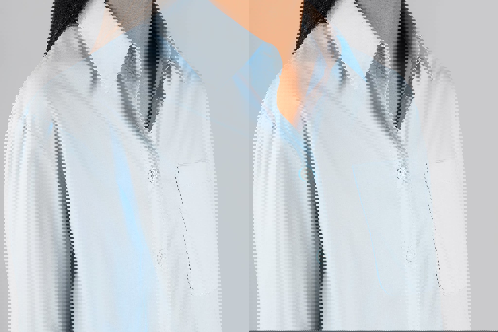 a woman is wearing a light blue shirt with buttons