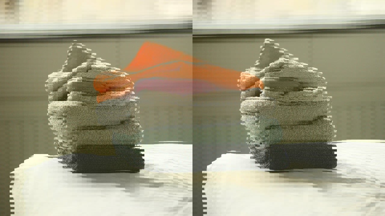 a stack of towels with a pink soap in the middle