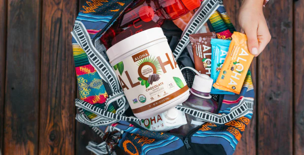 a person is holding a backpack filled with aloha products