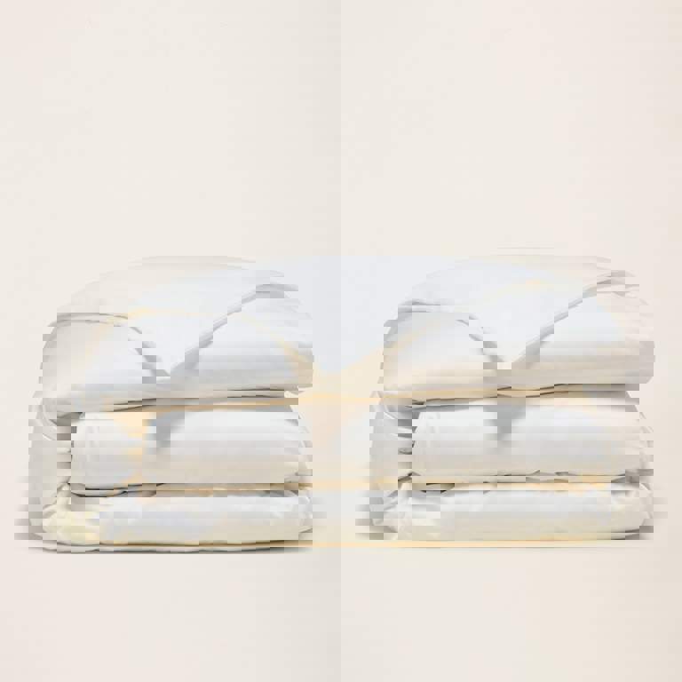 a white comforter is stacked on top of each other