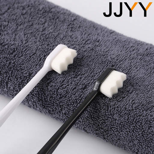 two toothbrushes on a gray towel with jjyy written on the bottom