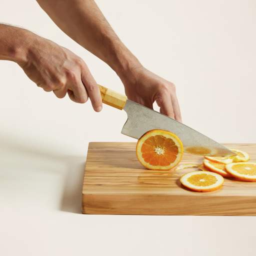 a person is cutting an orange on a cutting board