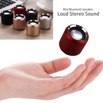 a hand is holding a small speaker that says mini bluetooth speaker loud stereo sound