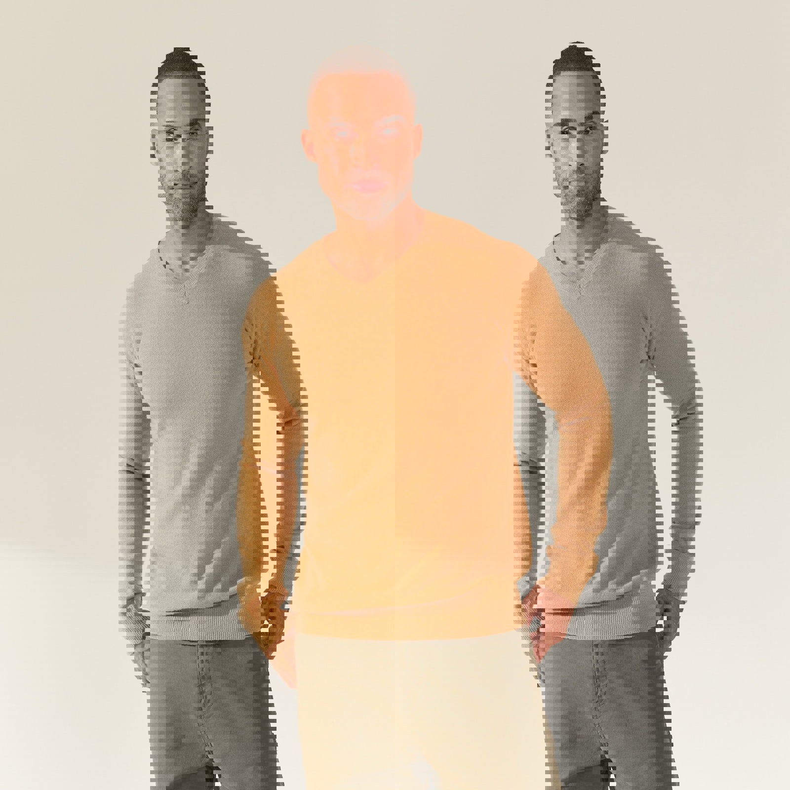 a man wearing a tan sweater and green shorts