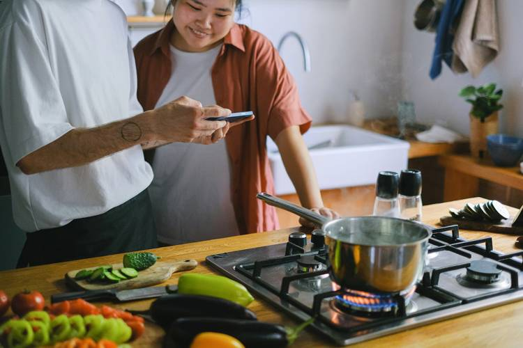 a man and woman are cooking in a kitchen