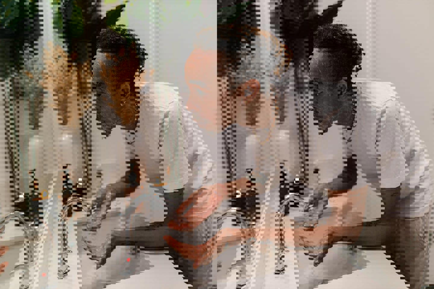 a man is washing his face in a bathroom sink