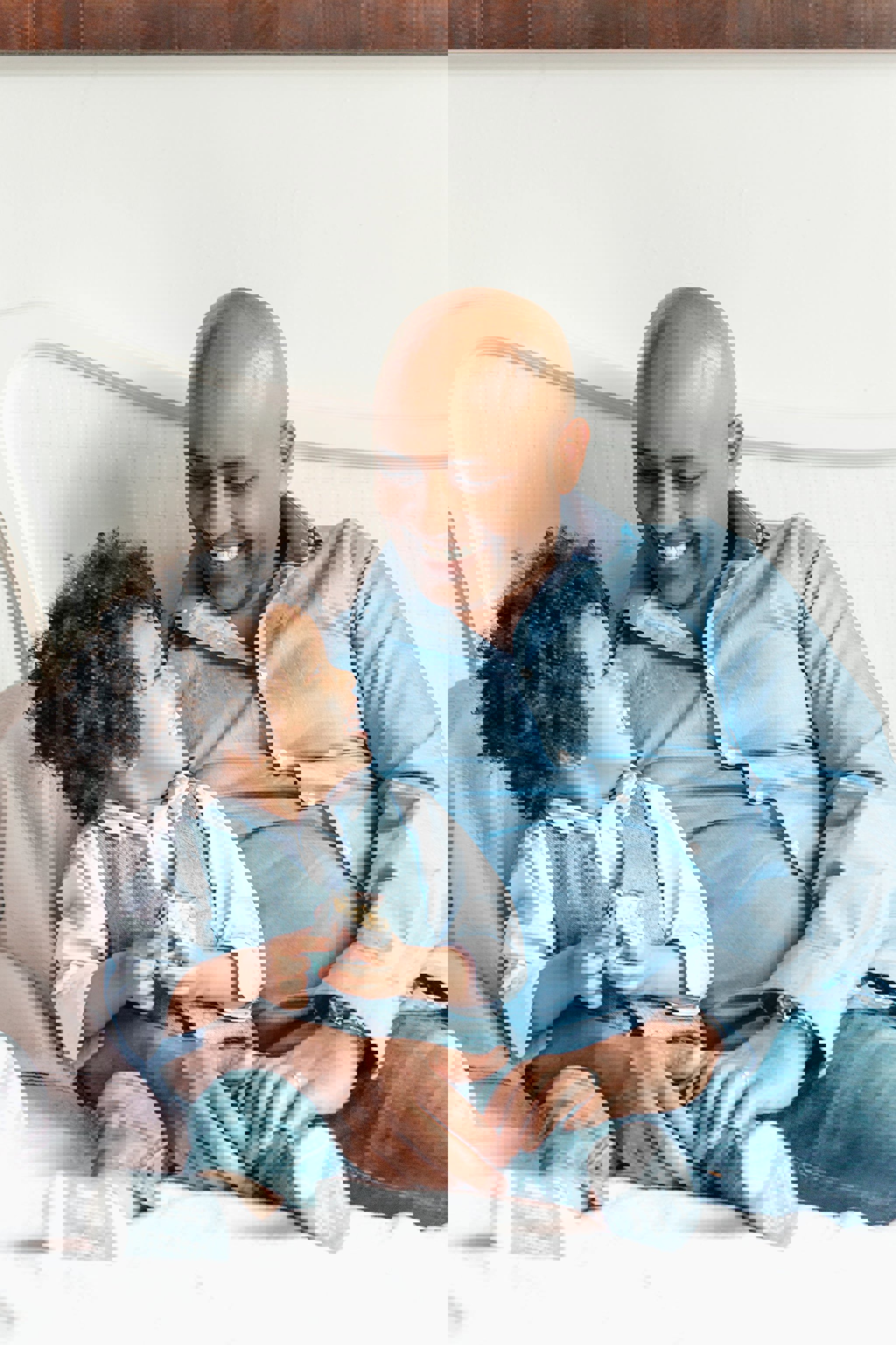 a man and a little boy are sitting on a bed and smiling