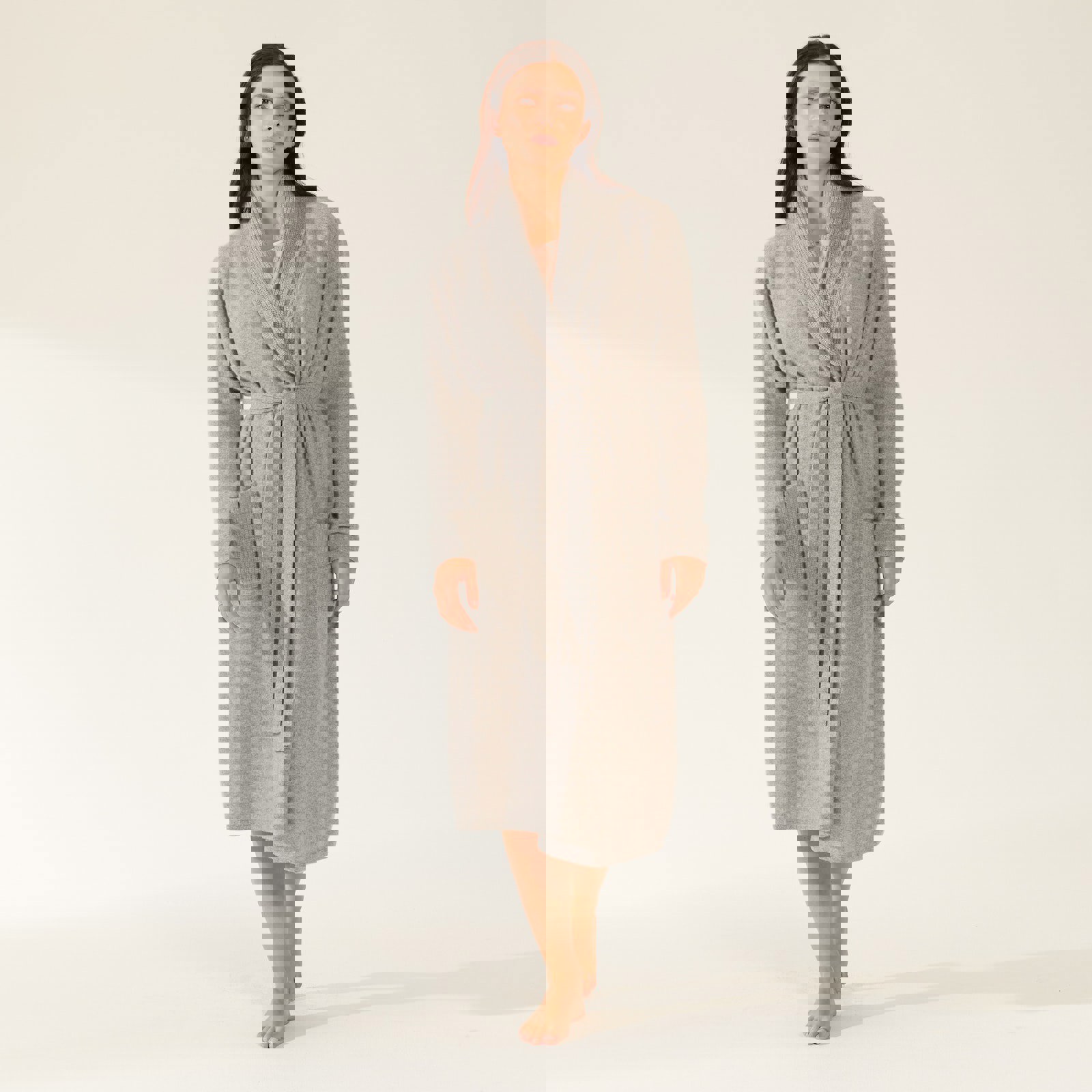 a woman is wearing a grey robe with pockets