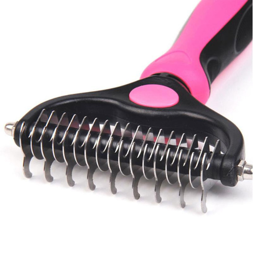 a close up of a brush with a pink handle