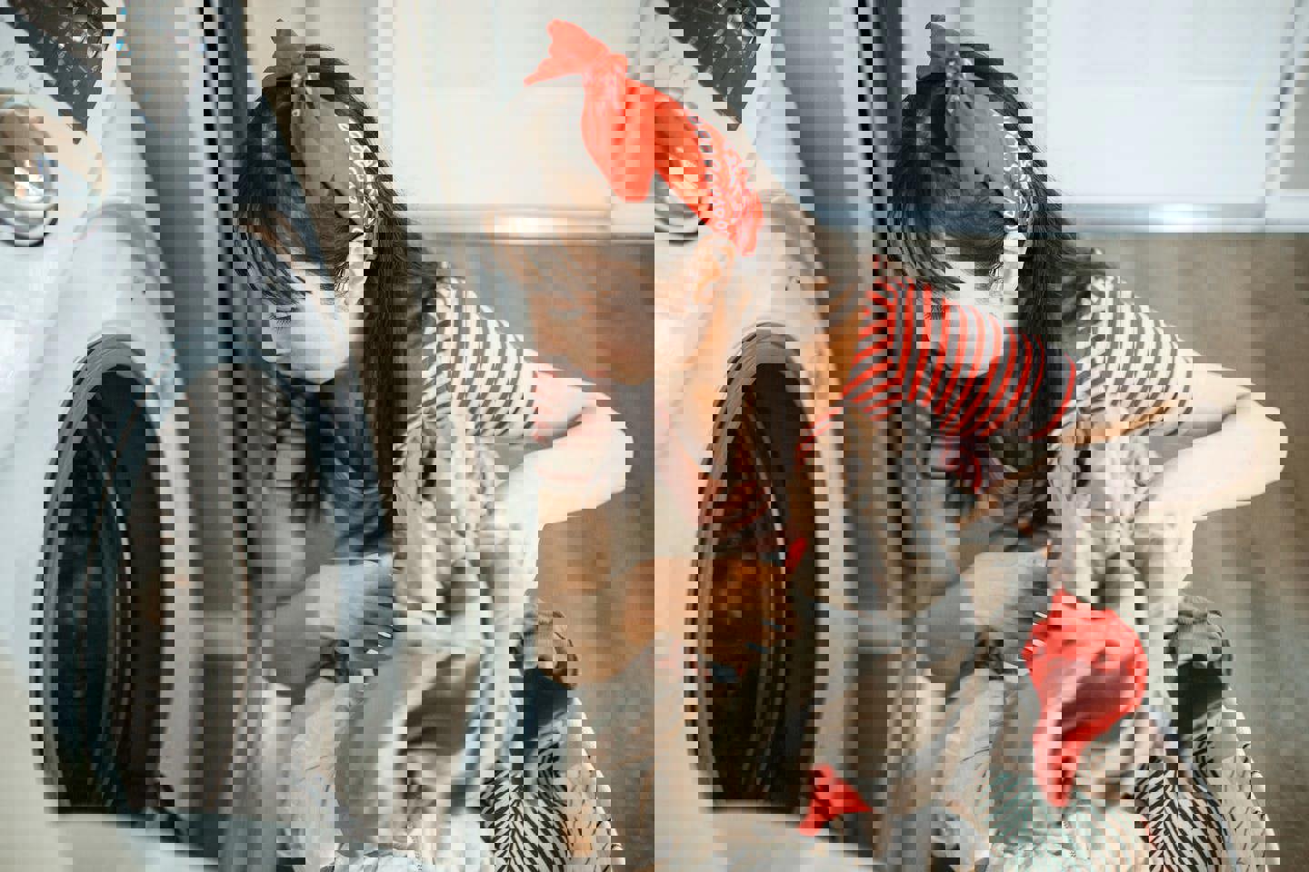 a woman is putting clothes in a washing machine