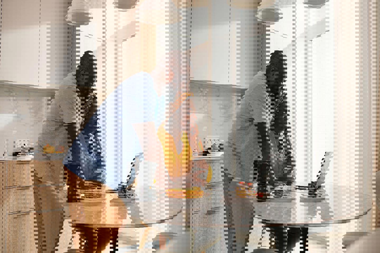 a man and a woman are sitting at a table looking at a laptop