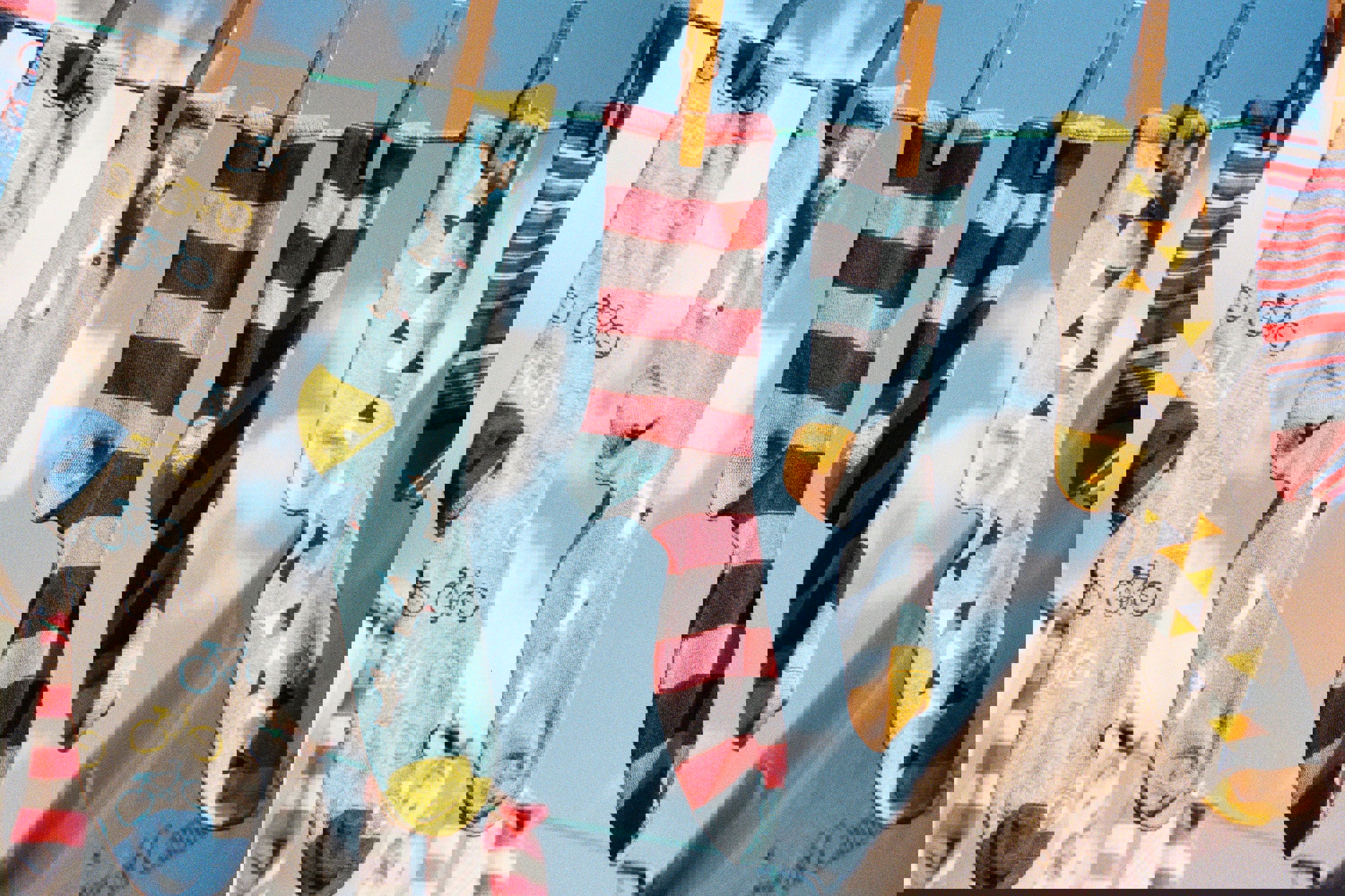 a bunch of colorful socks hanging on a clothes line