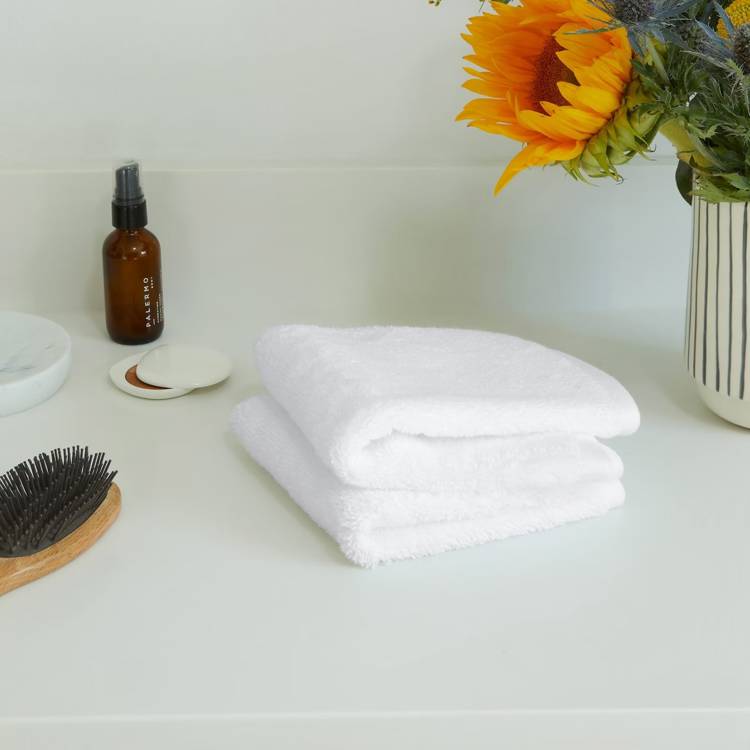 a white towel is stacked on top of another white towel