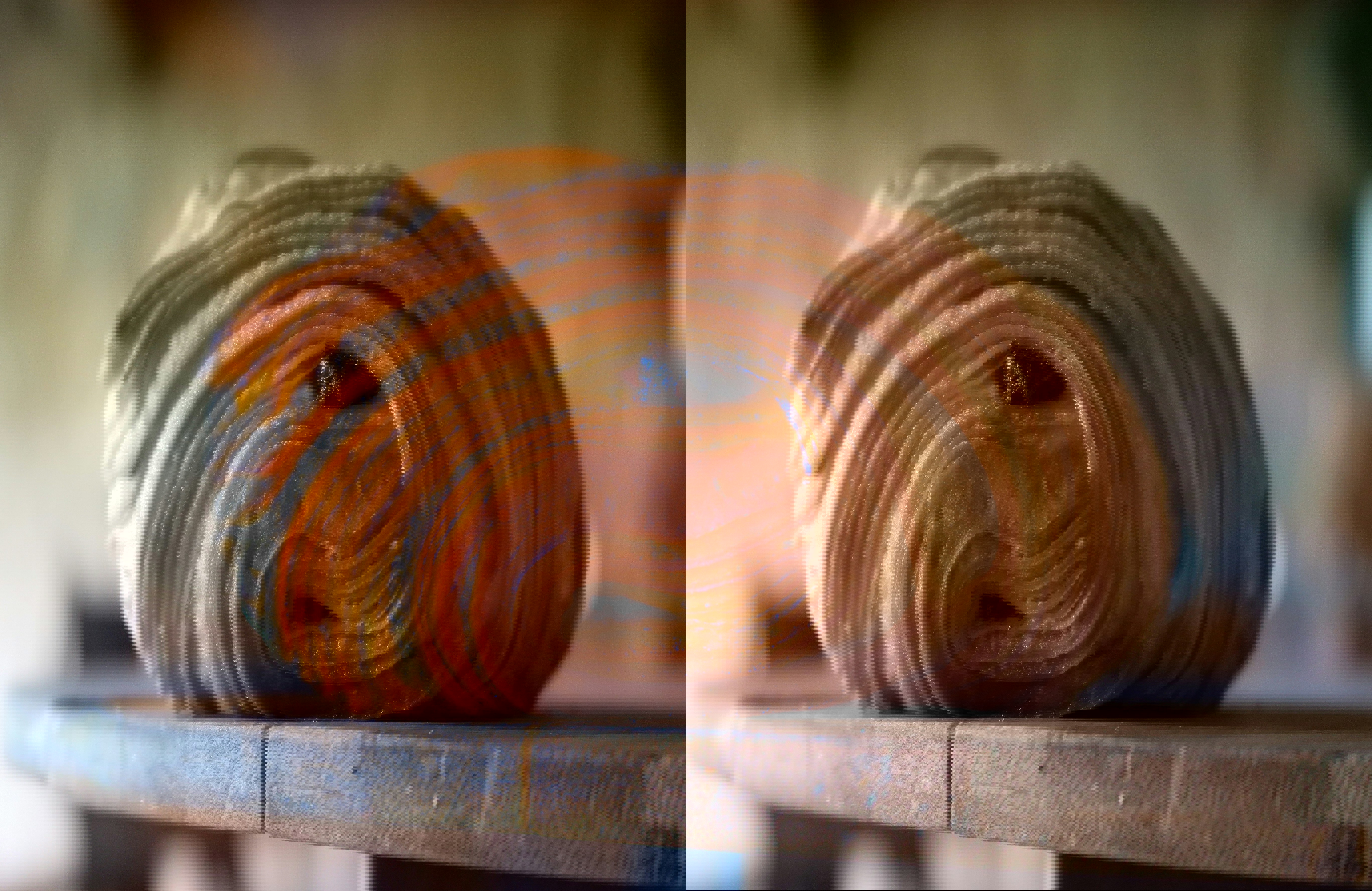 a close up of a chocolate croissant on a wooden cutting board