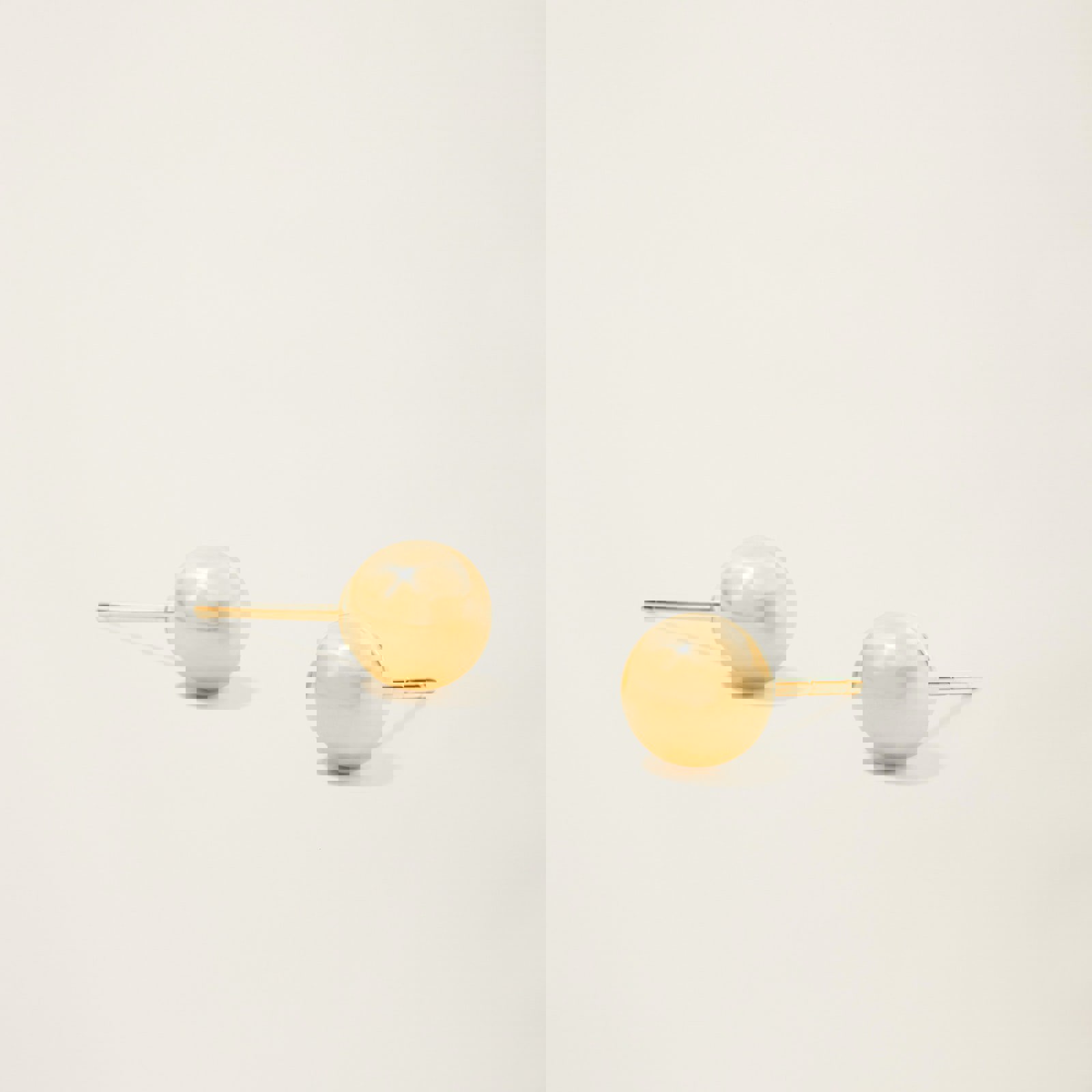 a pair of gold stud earrings on a white surface