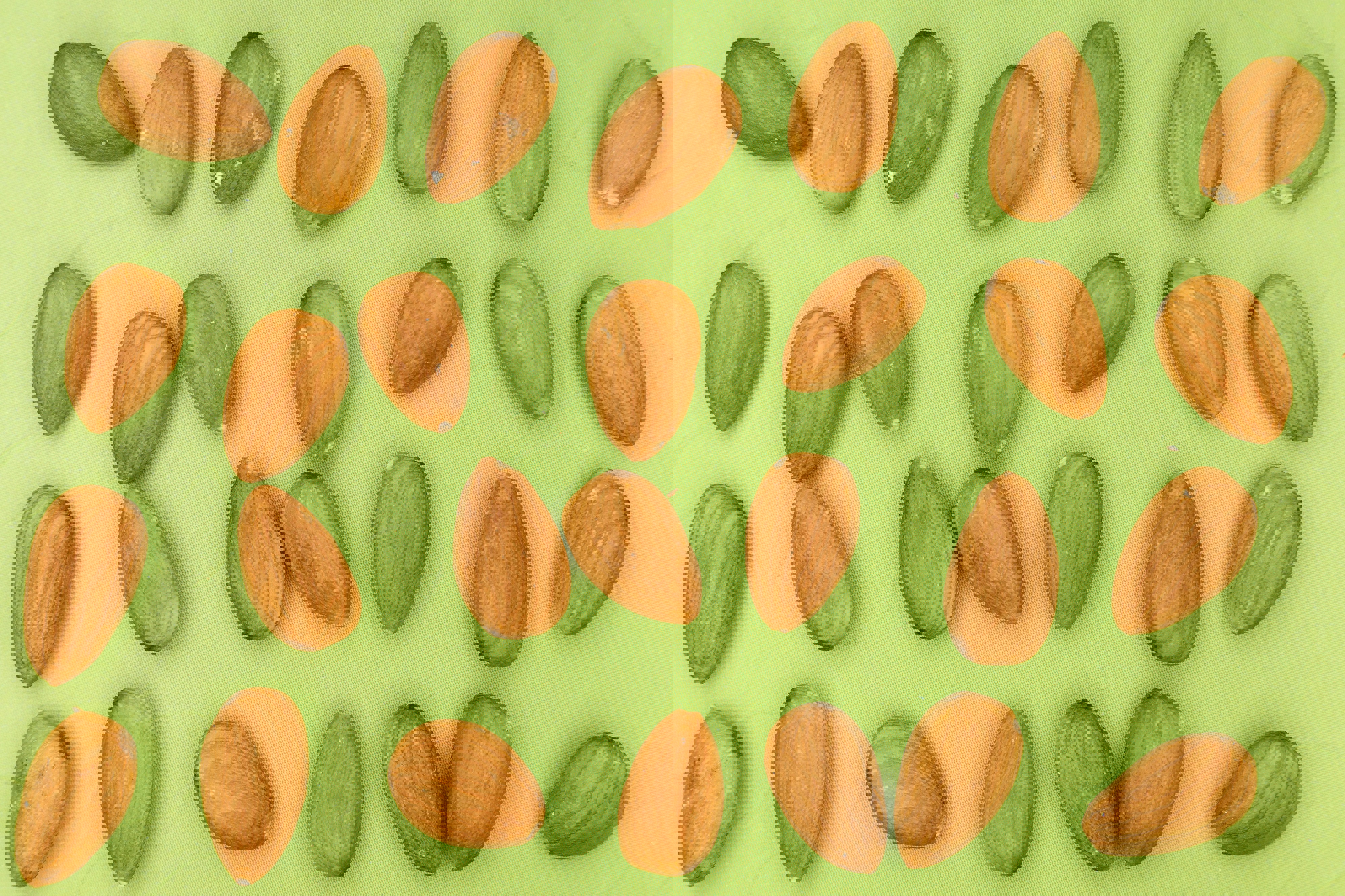 almonds are arranged in rows on a green surface