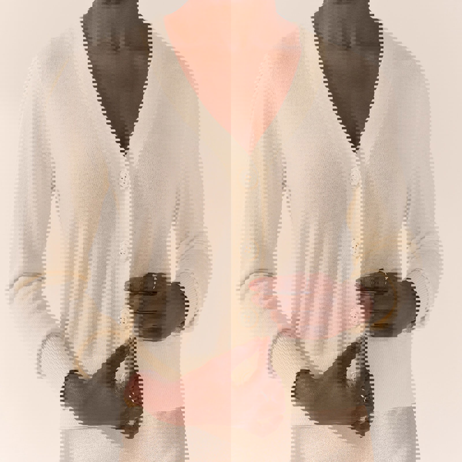 a woman wearing a white cardigan with white buttons