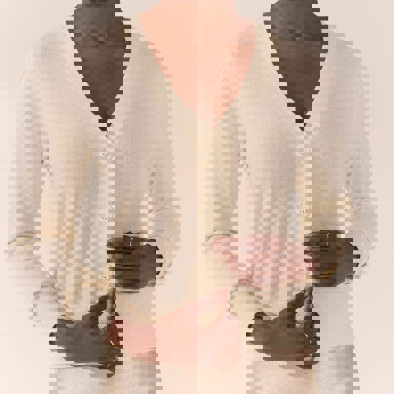 a woman wearing a white cardigan with white buttons