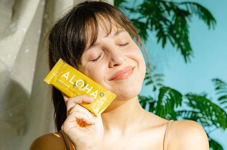 a woman is holding a aloha bar in front of her face