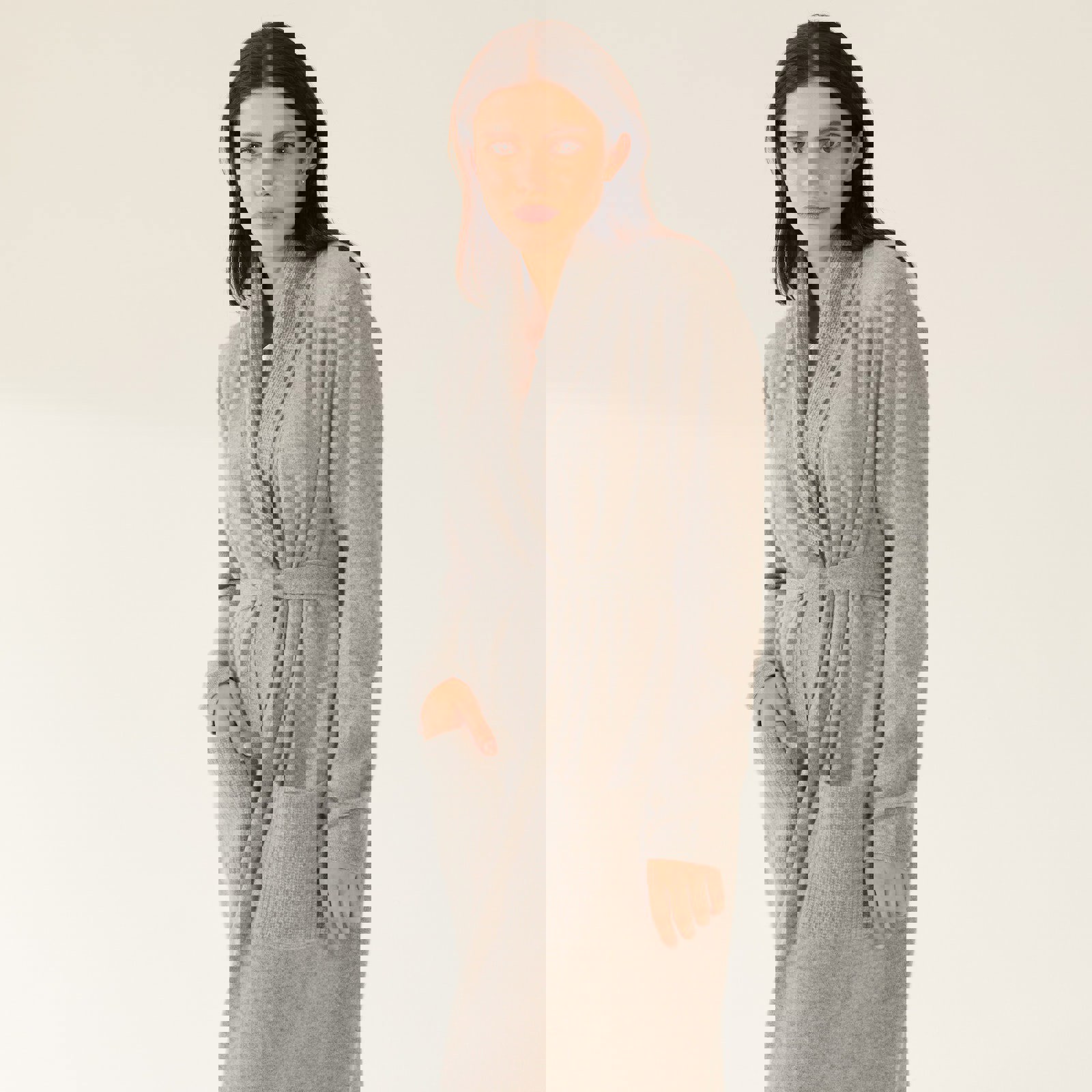 a woman is wearing a grey robe with pockets