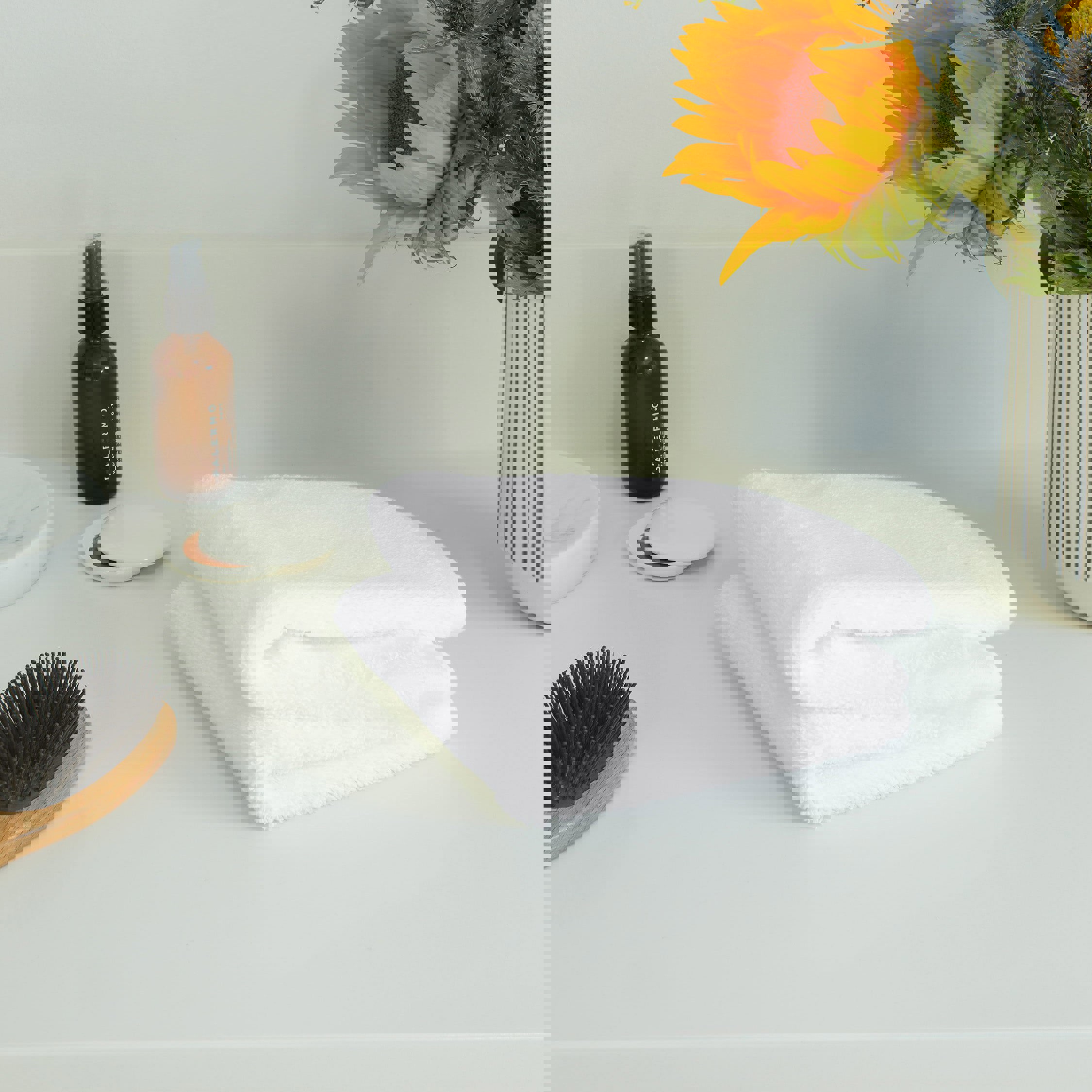 a white towel sits on a counter next to a bottle that says balmbu