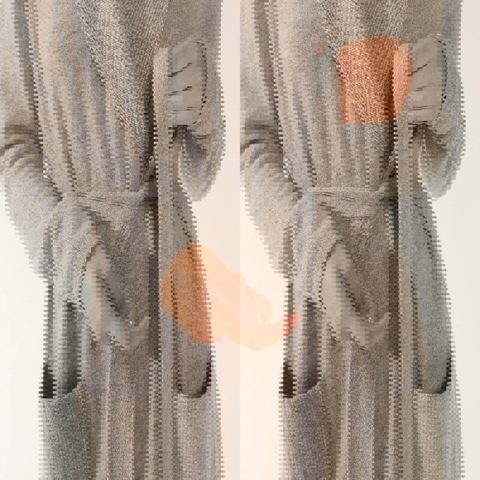 a woman wearing a grey robe with a belt around her waist