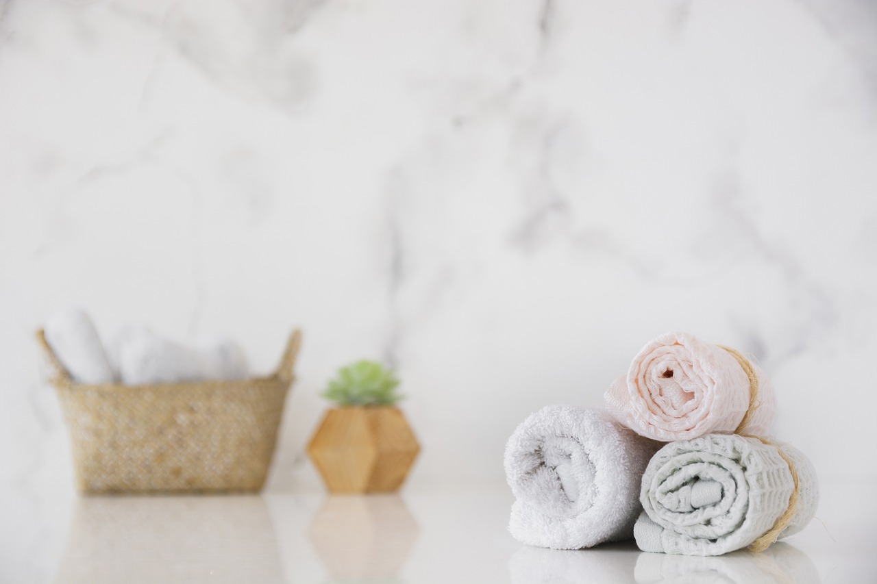 three towels stacked on top of each other with a basket in the background