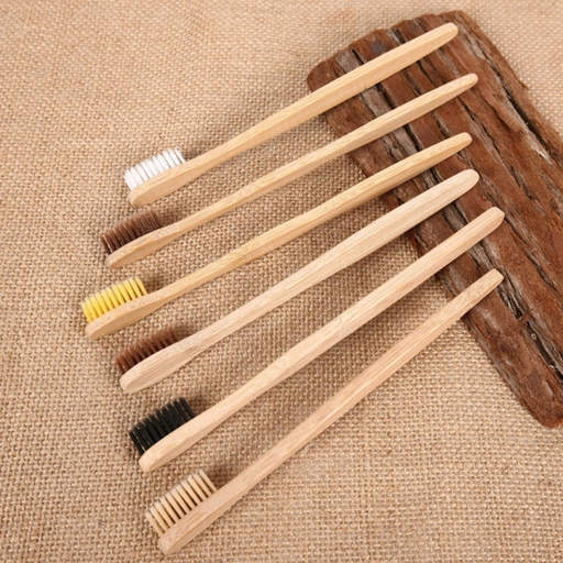 a row of wooden toothbrushes with different bristles