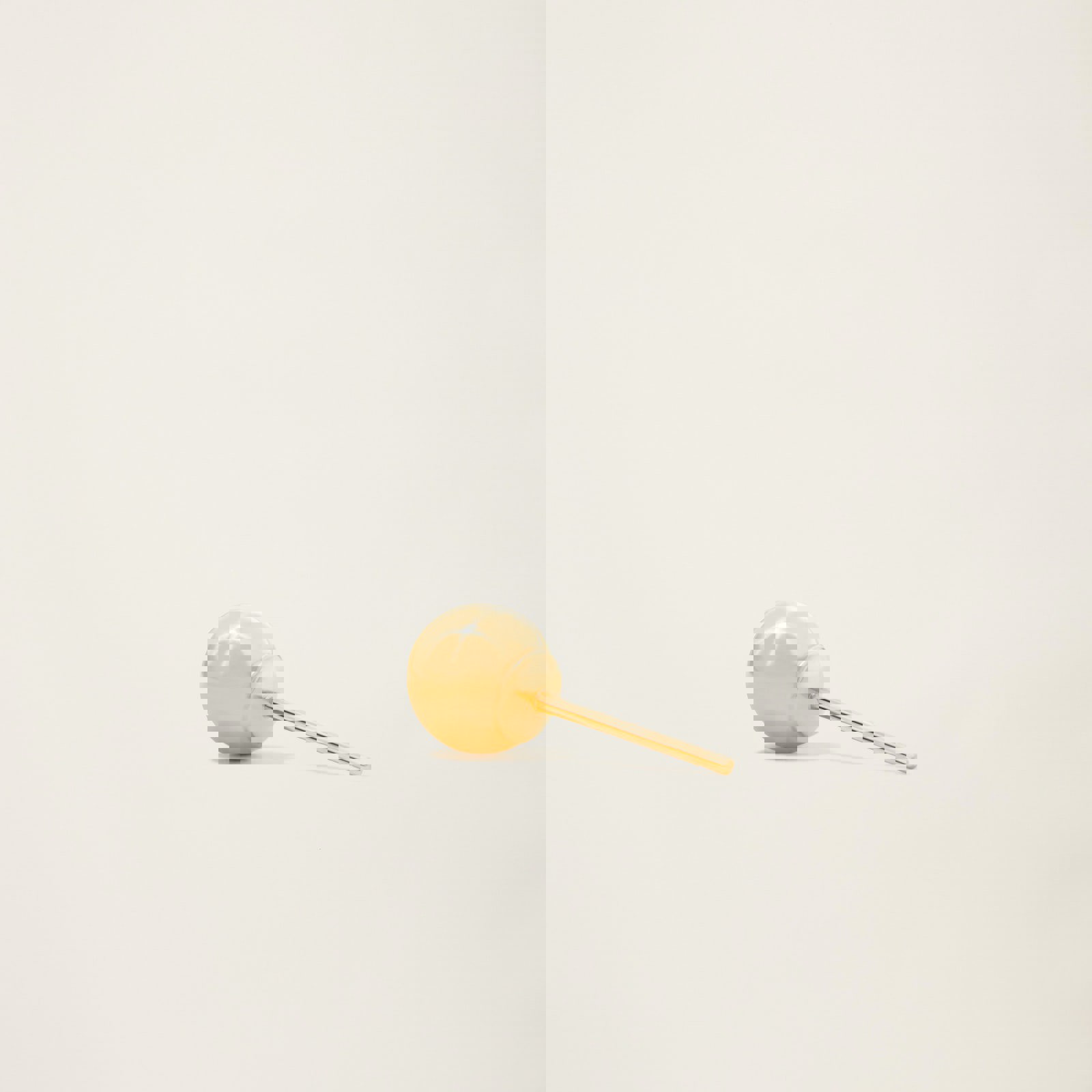 a gold earring is sitting on a white surface