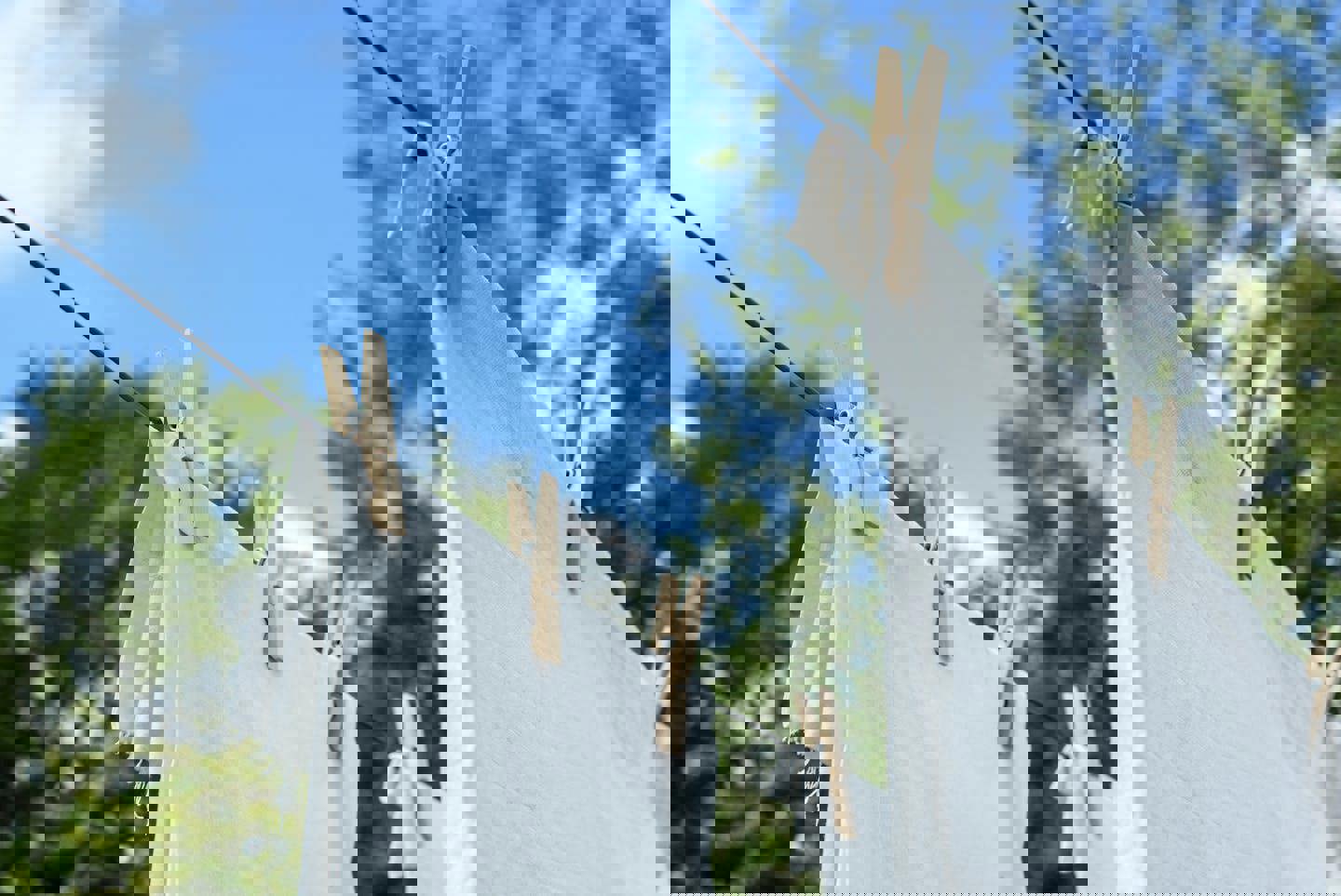 white clothes are hanging on a clothes line with wooden pegs