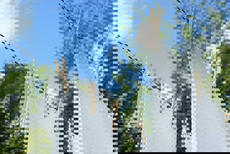white clothes are hanging on a clothes line with wooden pegs