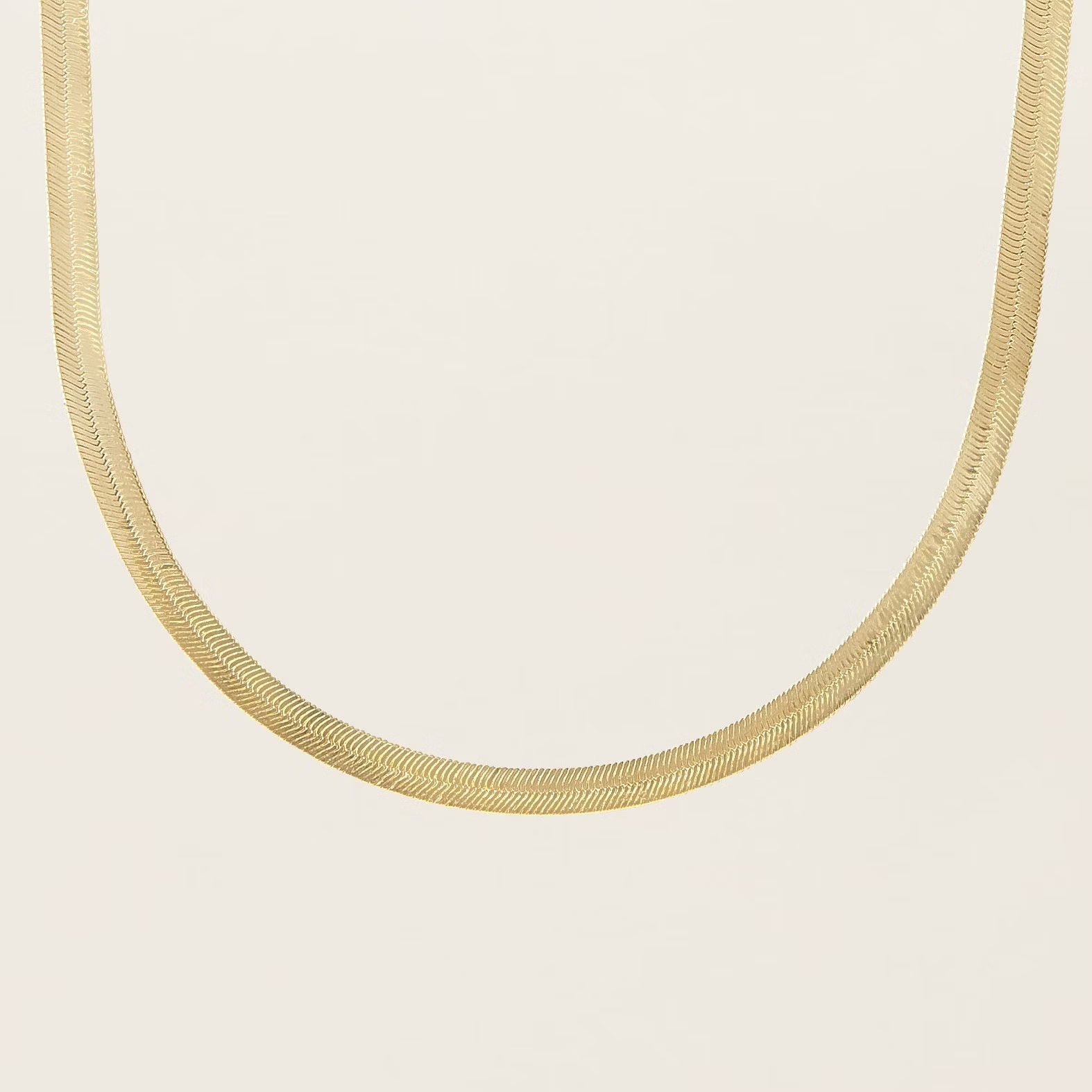 a close up of a gold chain necklace on a white background