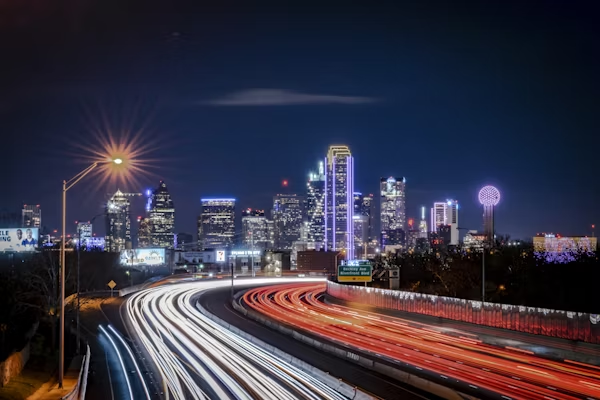 a highway with a city skyline in the background at night