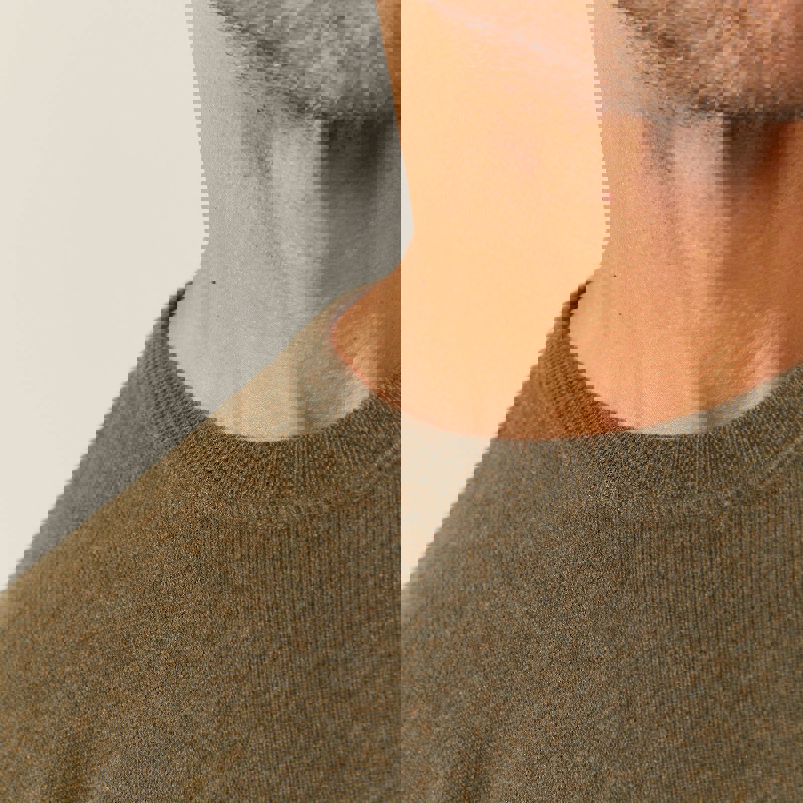 a close up of a man wearing a green sweater