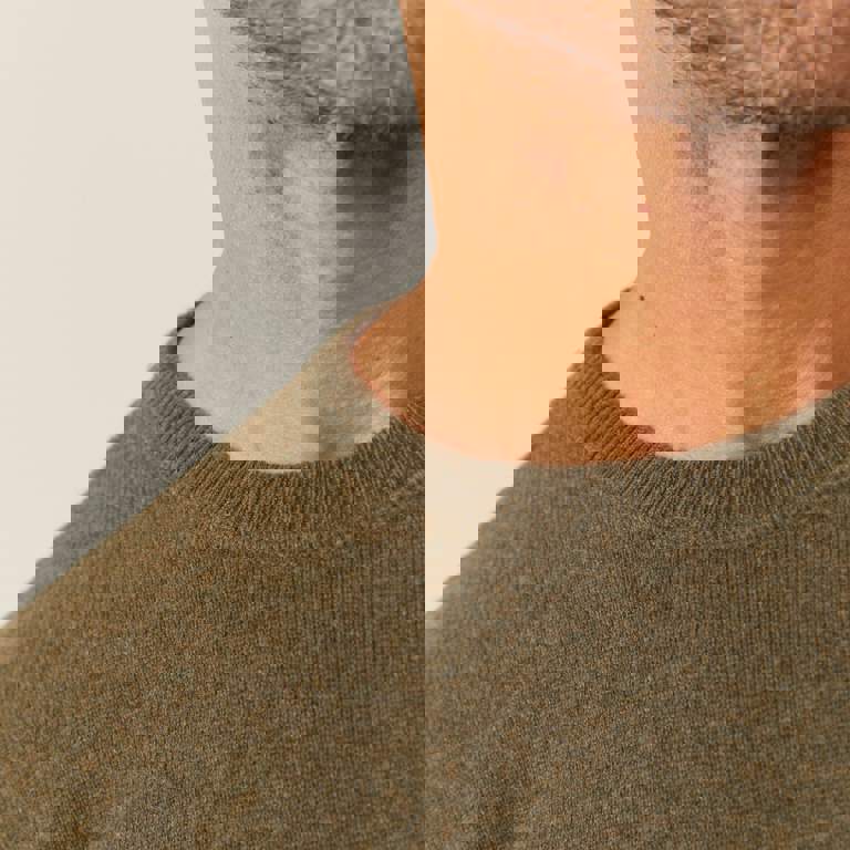 a close up of a man wearing a green sweater