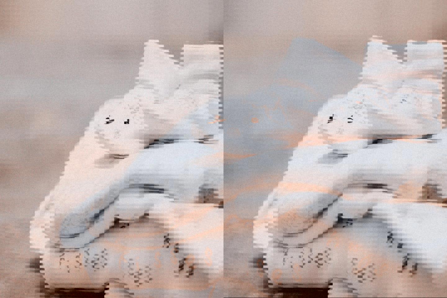 a stack of baby clothes that say kisses and hugs