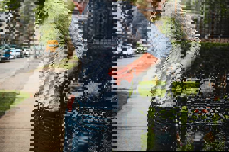 a man leaning on a fence with his hands in his pockets