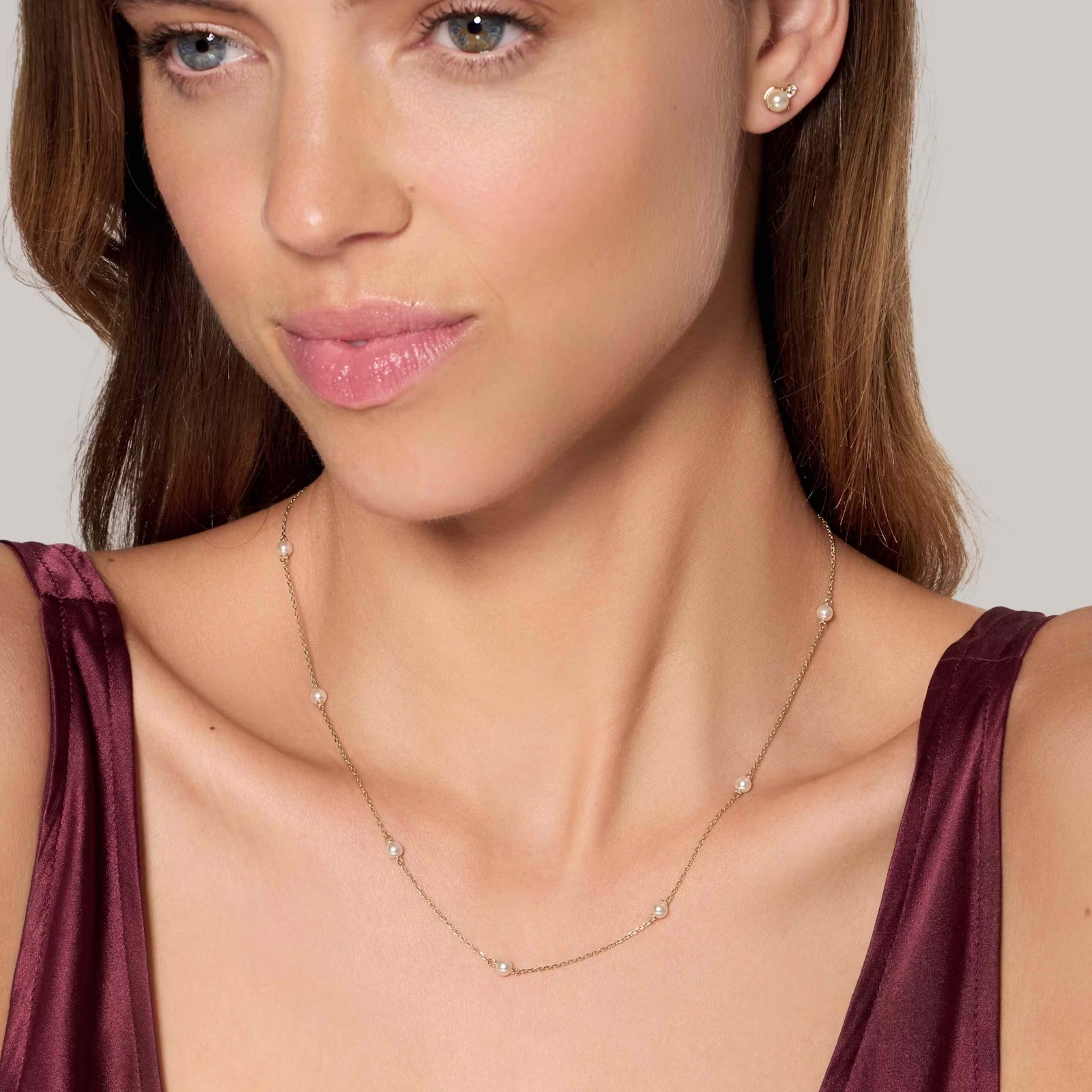 a woman is wearing a necklace and earrings