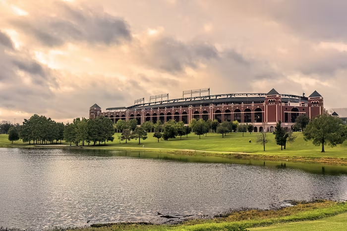 a large brick stadium with a lake in front of it