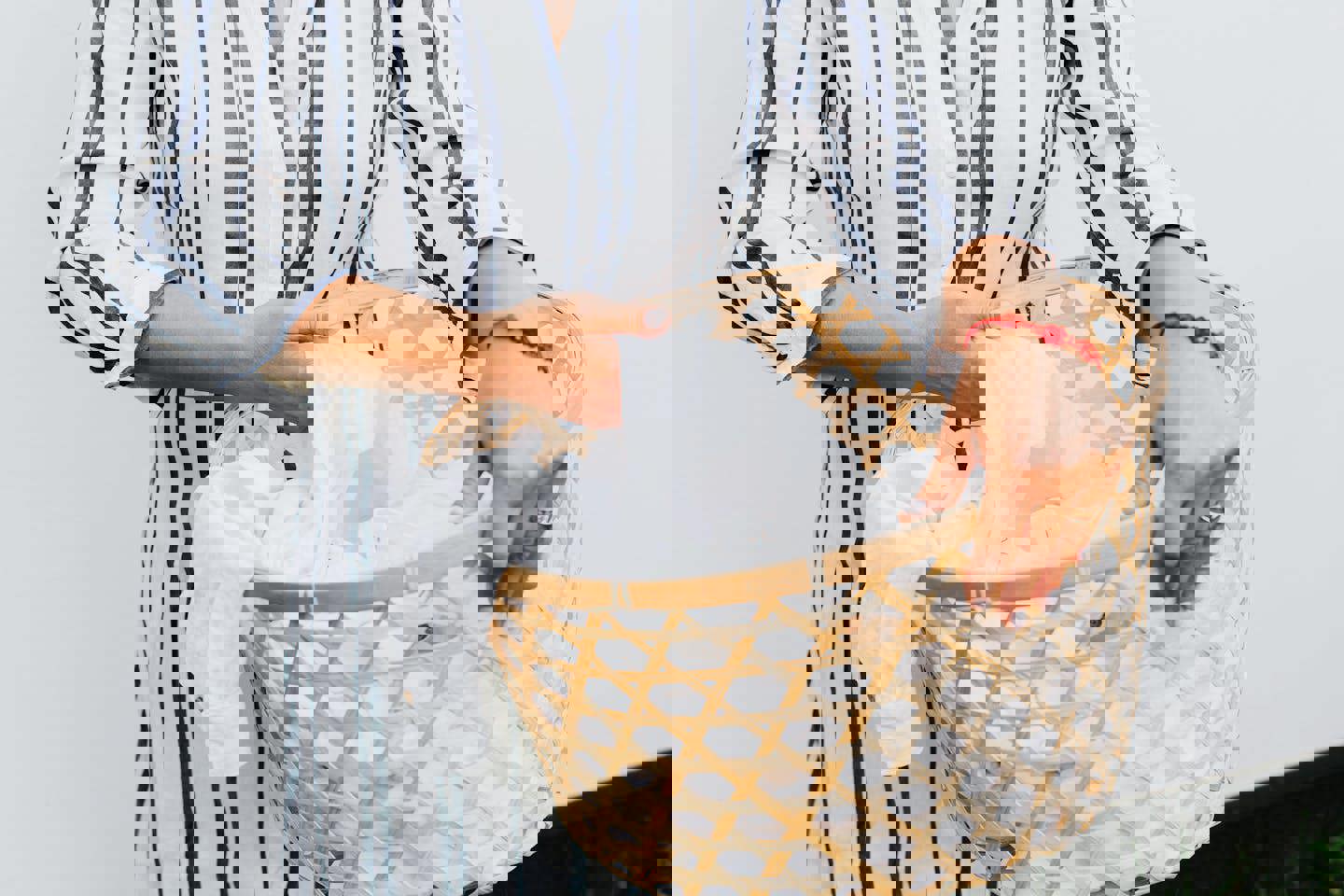 a woman is holding a laundry basket filled with white clothes