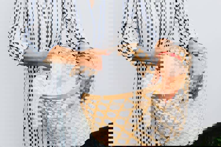 a woman is holding a laundry basket filled with white clothes