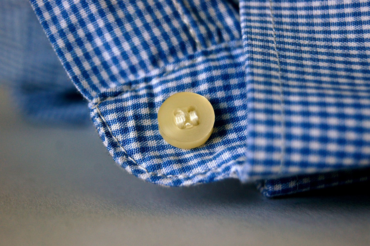 a blue and white checkered shirt has a button on the sleeve