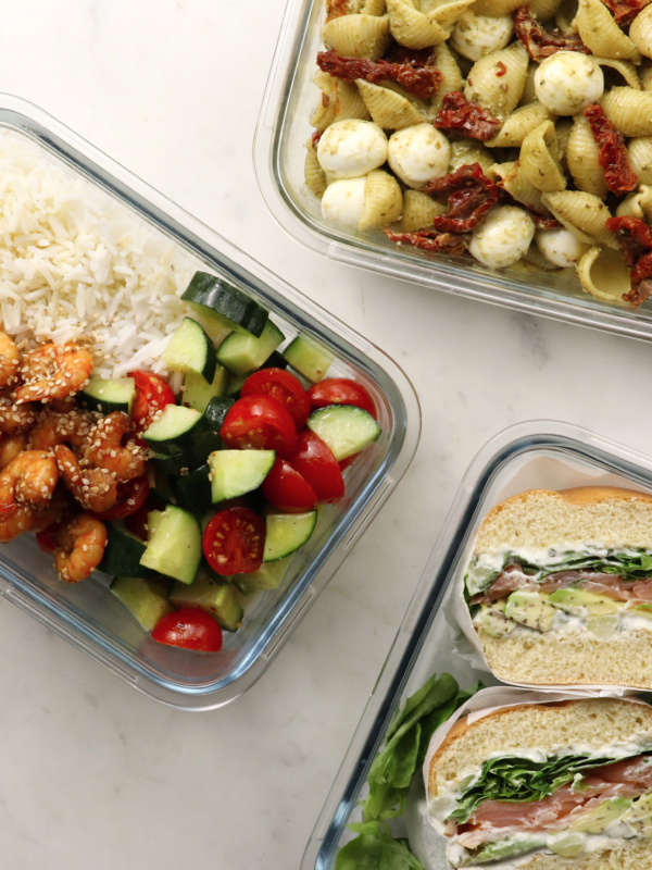 three containers of food including a sandwich and pasta