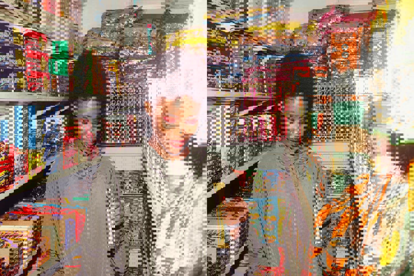 a woman in a grocery store holding a bag of pringles