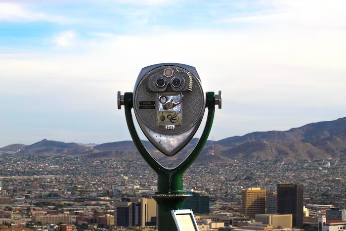 a coin operated binoculars with a view of a city