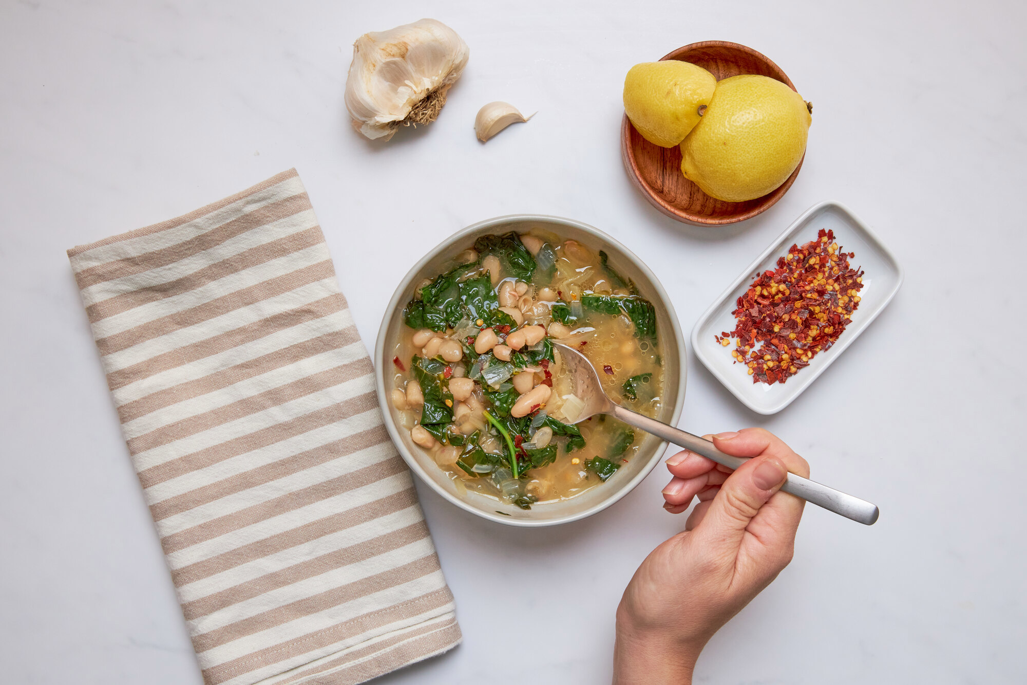 a person is eating a bowl of soup with a spoon