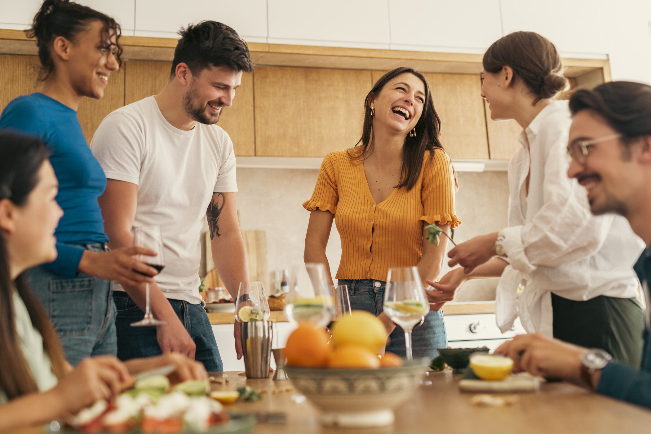 a group of people are gathered around a table in a kitchen